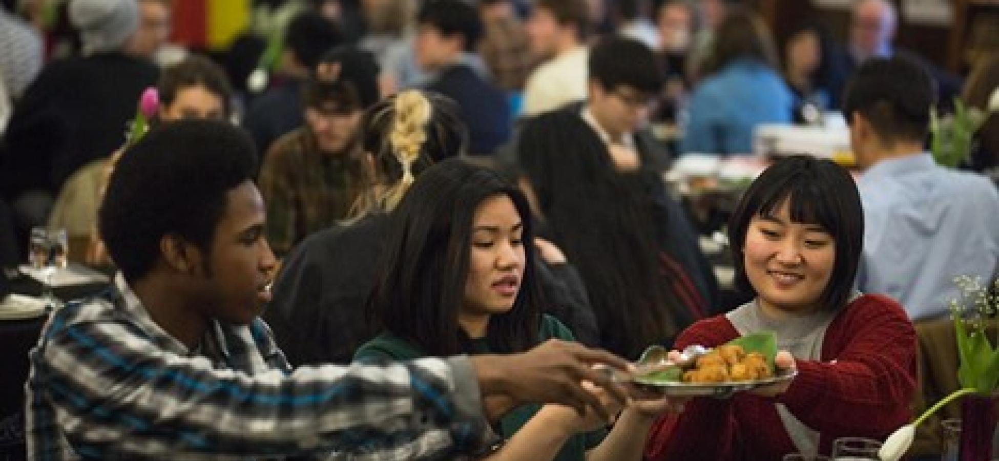 Students eating at gathering in dining hall.